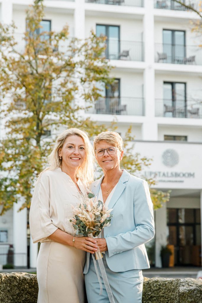 Zwei lächelnde Frauen stehen vor Hotelgebäude