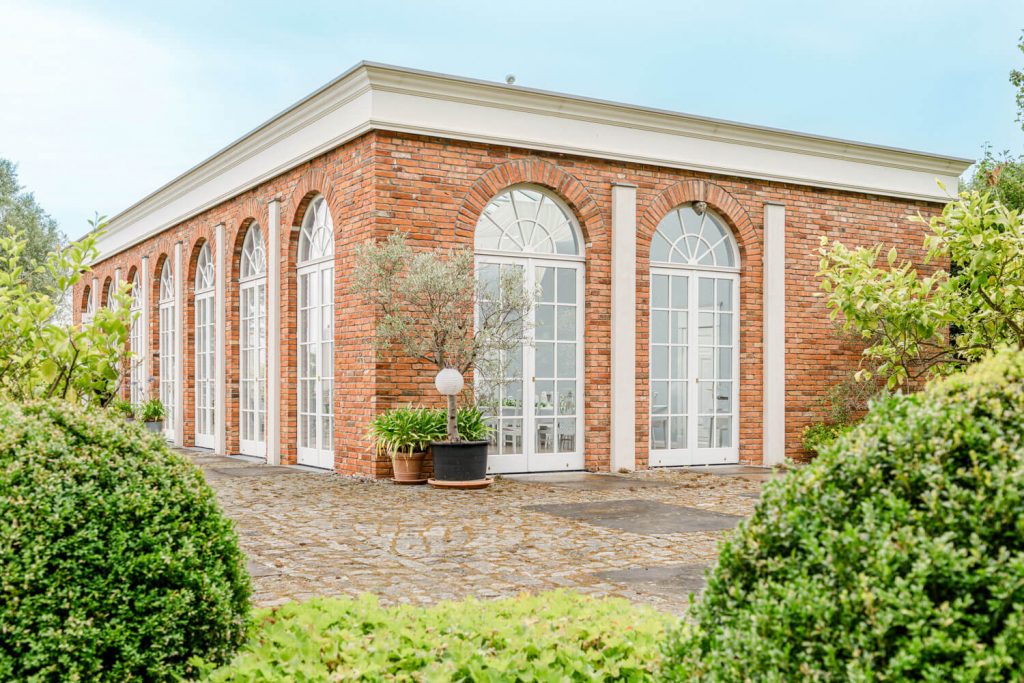 Hochzeitsfotograf, Gut Groß Siemen. Backsteinbau mit großen Fenstern und grünem Garten