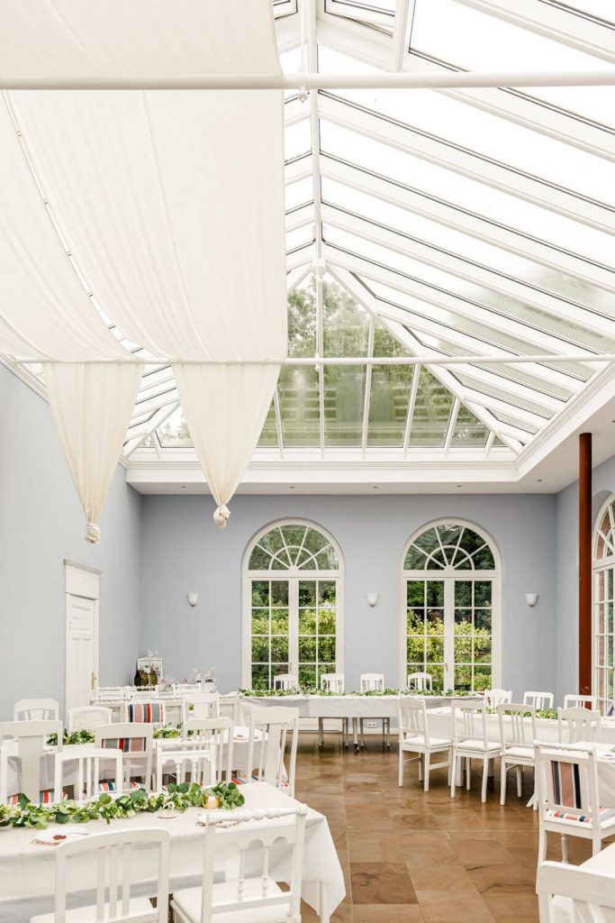 Gut Groß Siemen. Heller Hochzeitsort mit gläsernem Dach und Dekorationen