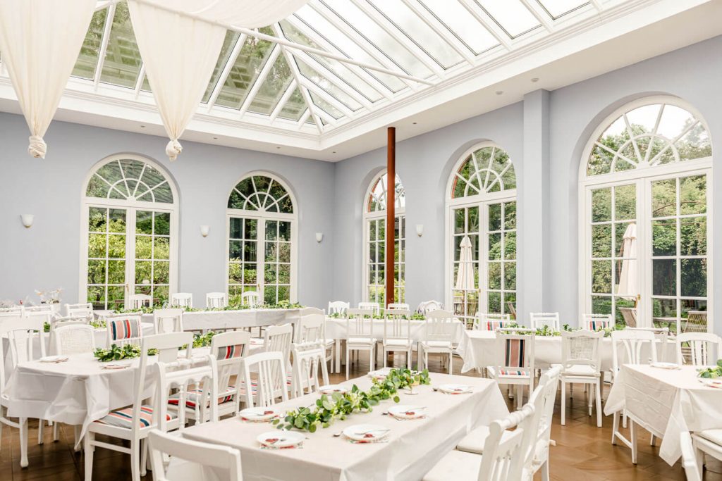 Gut Groß Siemen. Elegantes Restaurant mit weißem Interieur und Glasdach