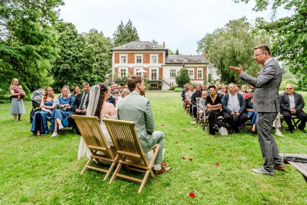 Hochzeitszeremonie im Freien vor historischem Gebäude. Gut Groß Siemen.