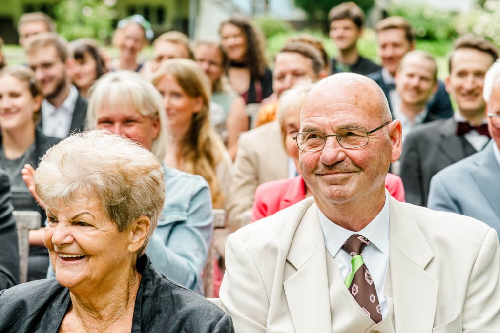 Älteres Paar lächelt bei einer Veranstaltung draußen