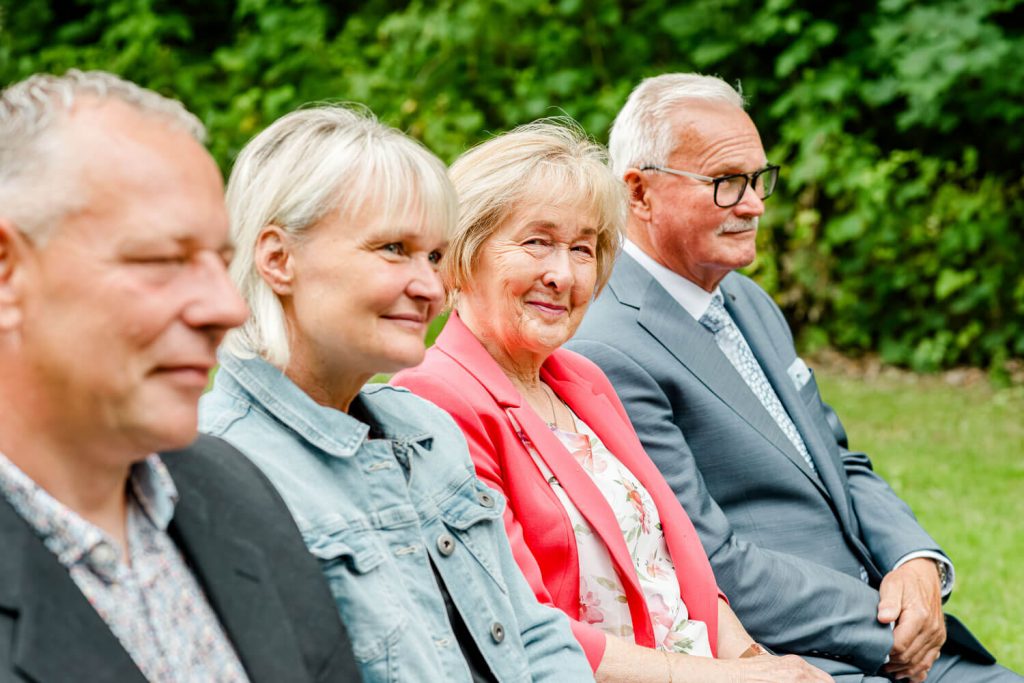 Ältere Menschen sitzen lächelnd an der frischen Luft