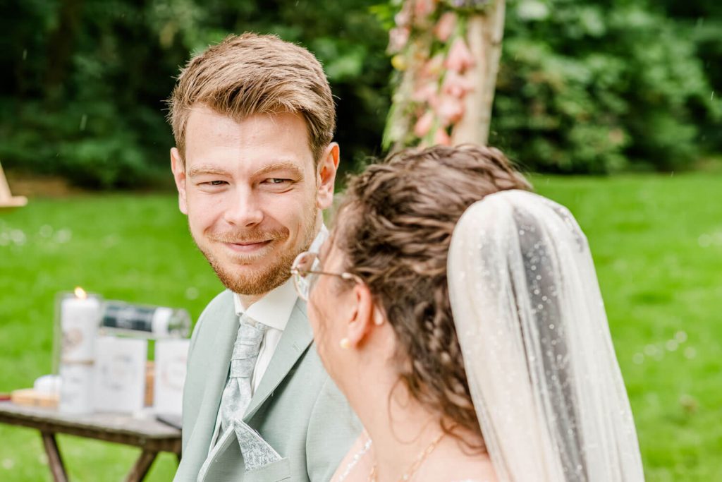 Paar lächelt sich bei einer Hochzeit an.