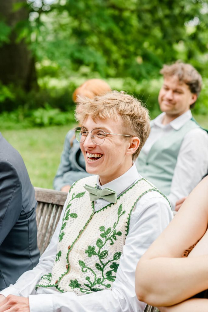 Lachender Mann in eleganter Weste bei Feier