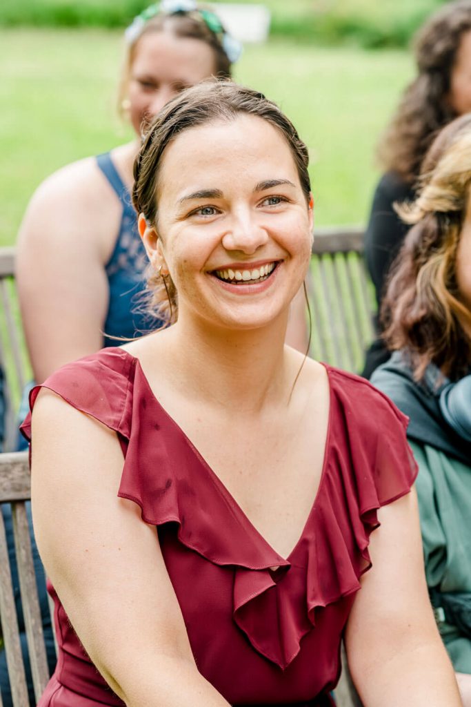 Fröhliche Frau im Freien bei Veranstaltung sitzend