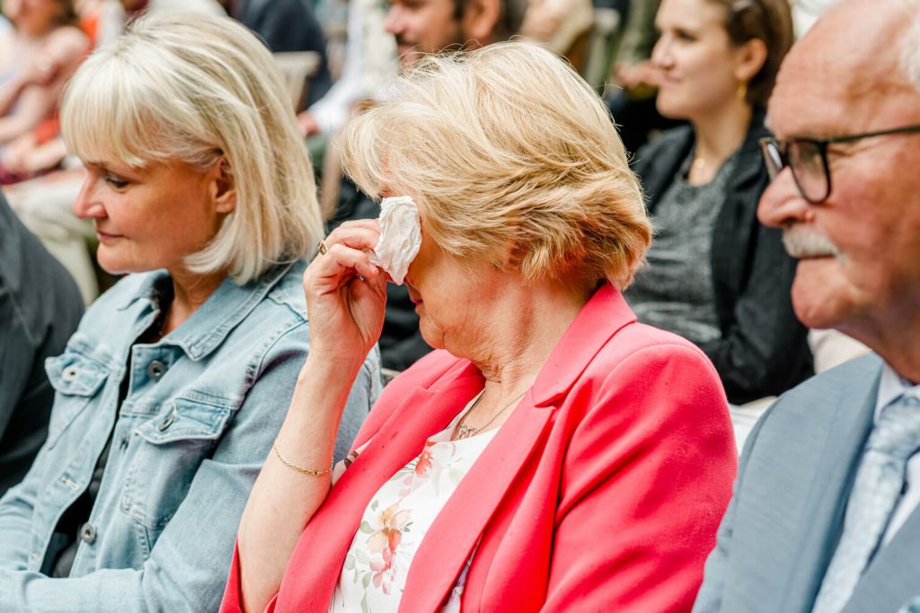 Ältere Menschen sitzen bei emotionaler Veranstaltung zusammen.