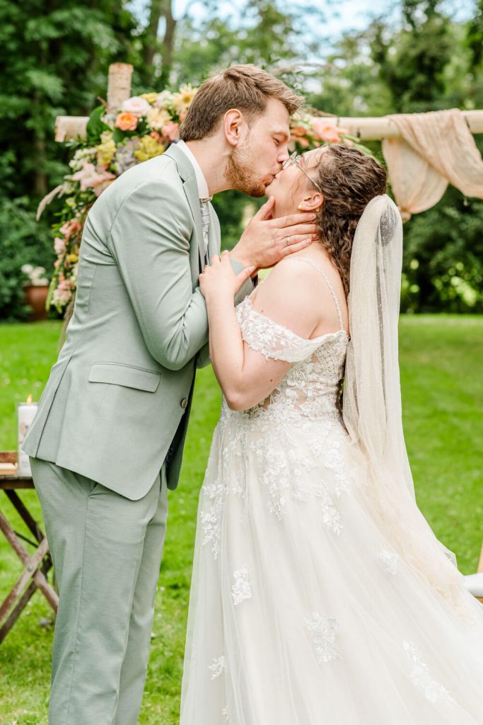 Hochzeitspaar teilt einen romantischen Kuss im Freien