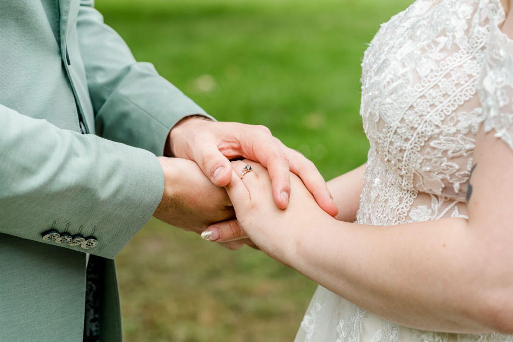 Braut und Bräutigam halten sich liebevoll Hände