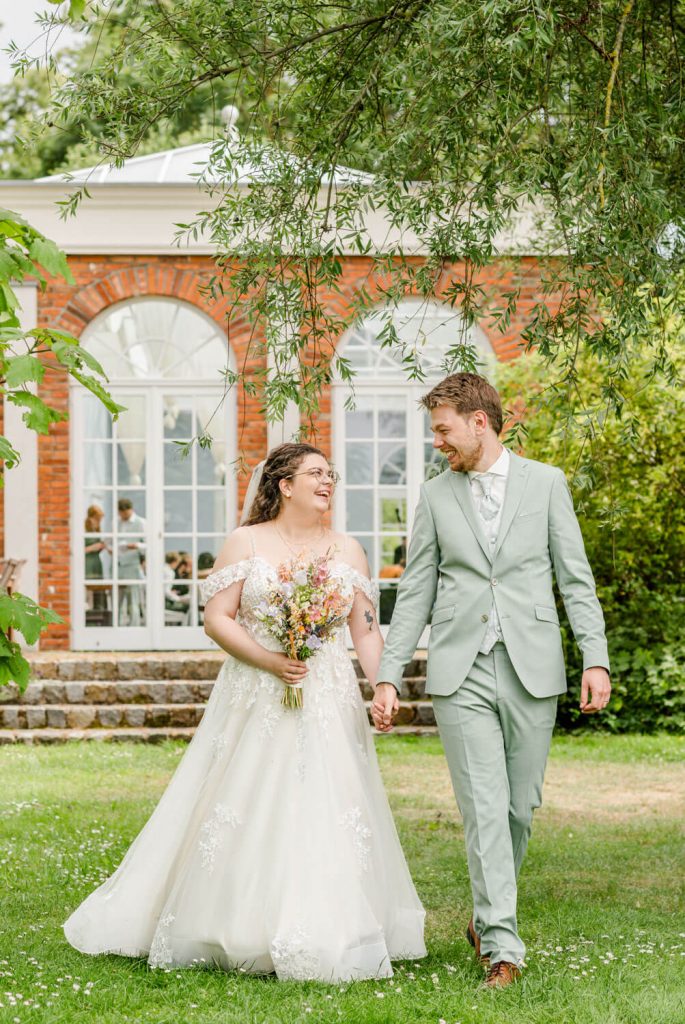 Gut Groß Siemen. Junges Hochzeitspaar spaziert im Garten glücklich