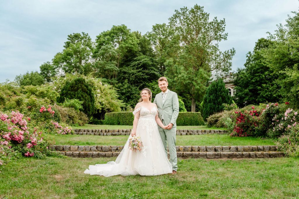 Gut Groß Siemen. Brautpaar im Garten bei Hochzeitsfotosession posierend