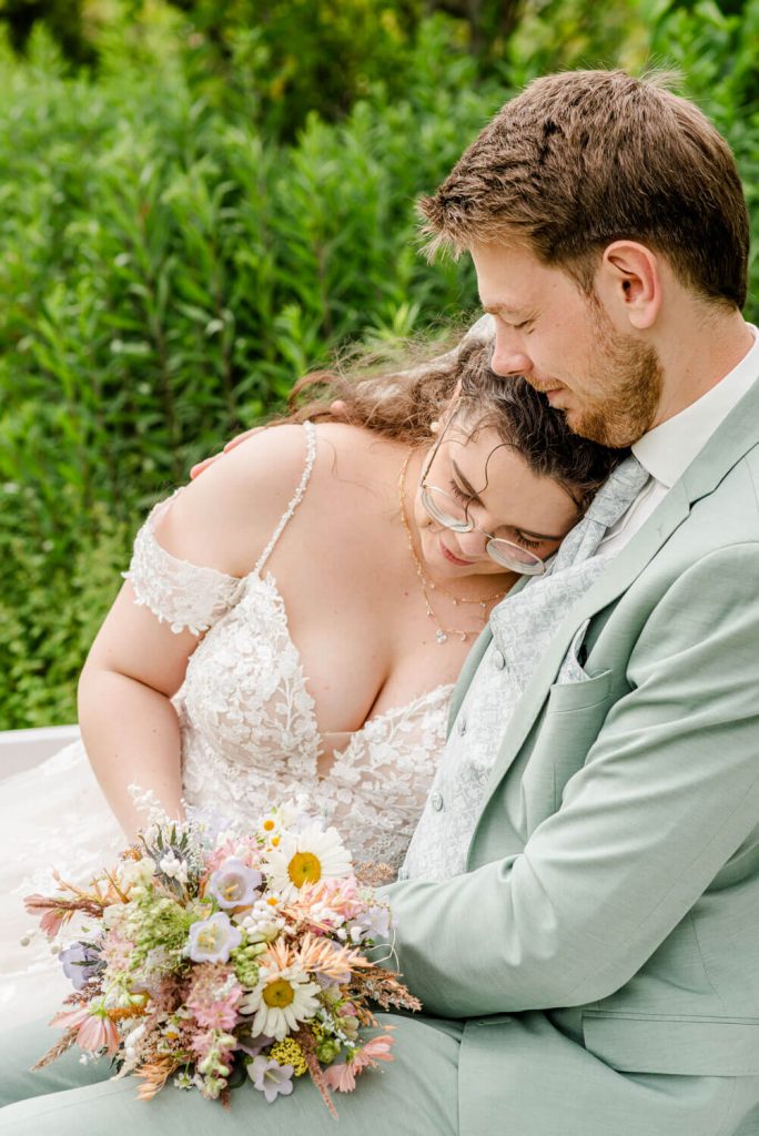 Gut Groß Siemen. Brautpaar im Garten mit Blumenstrauß posiert.