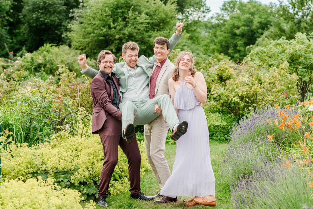 Vier fröhliche Menschen posieren im Garten zusammen