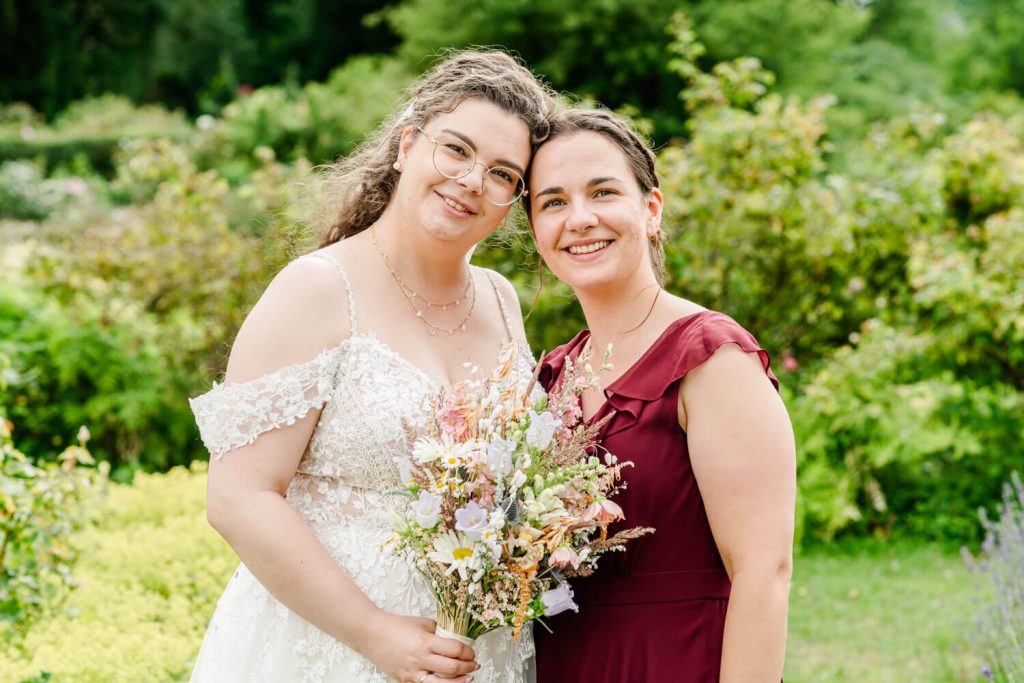 Zwei Frauen lächelnd in einem Garten stehen