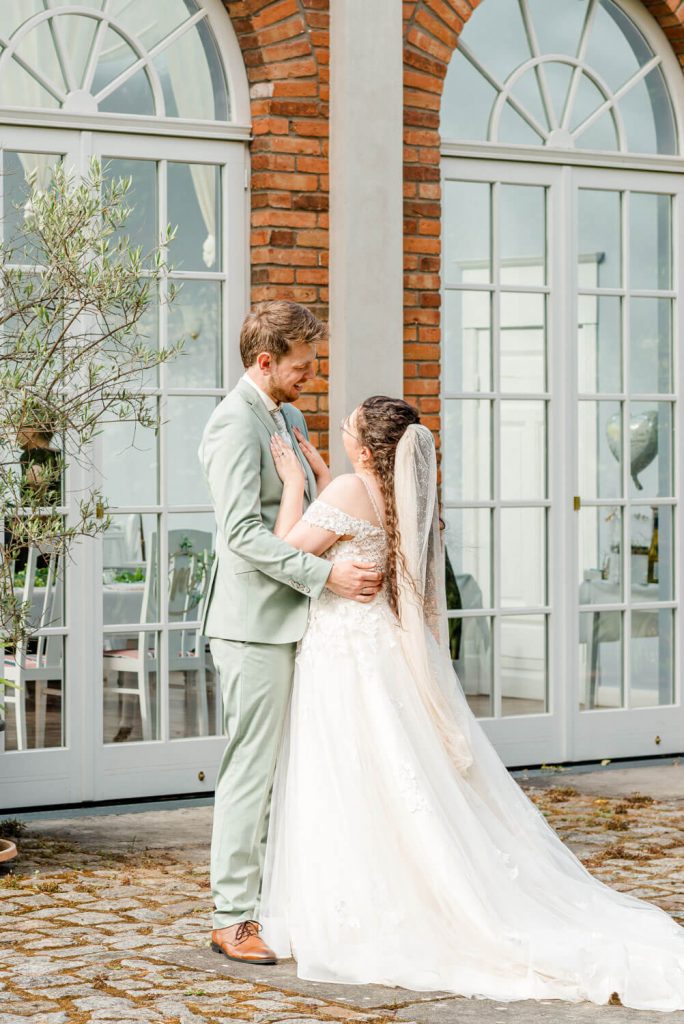 Brautpaar tanzt vor elegantem Hochzeitsort am Tag