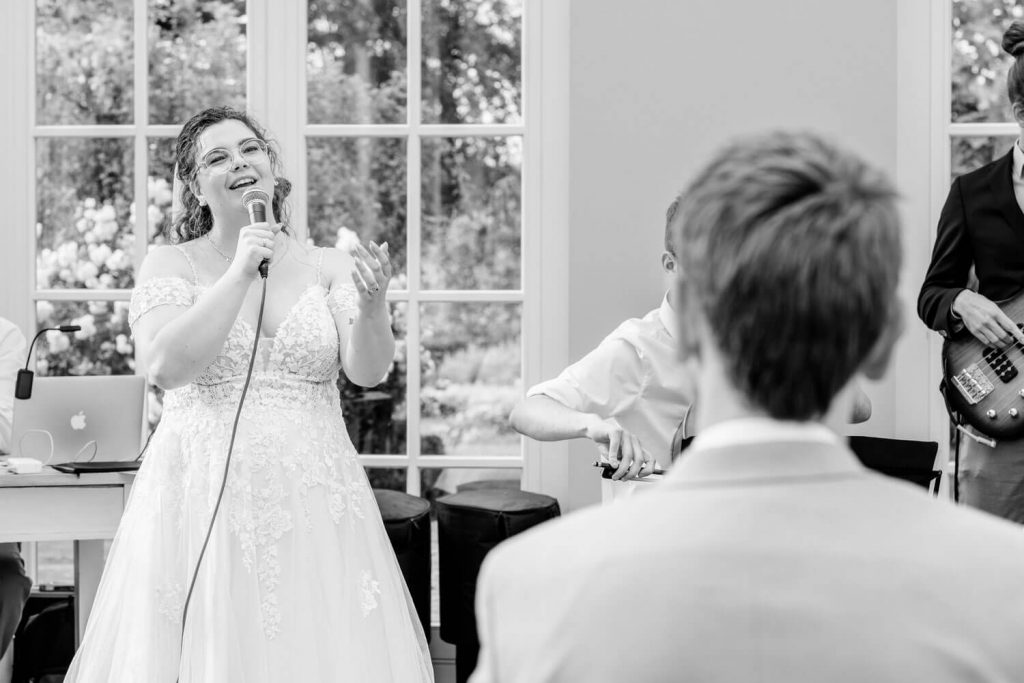 Braut singt auf Hochzeit vor Gästen glücklich