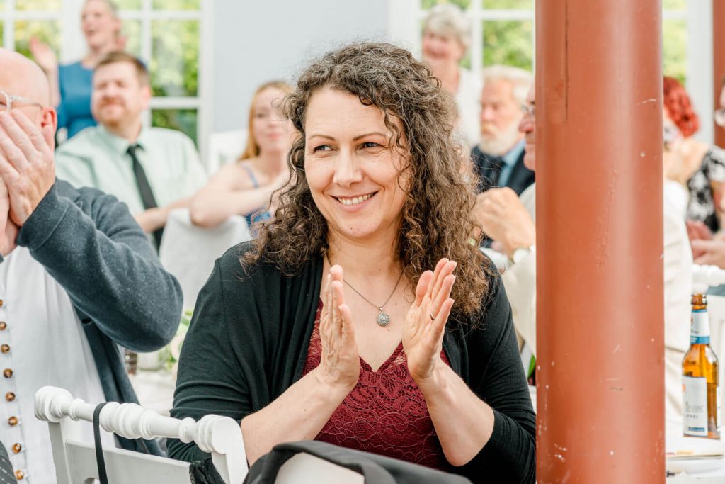 Frau bei fröhlicher Veranstaltung mit anderen Gästen