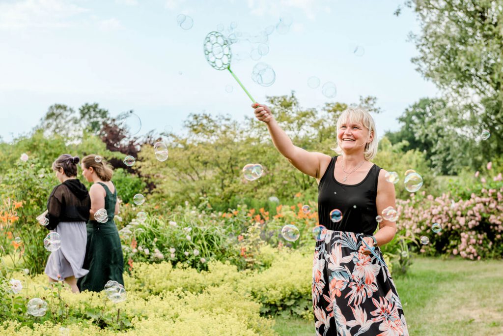 Frau macht Seifenblasen im grünen Garten