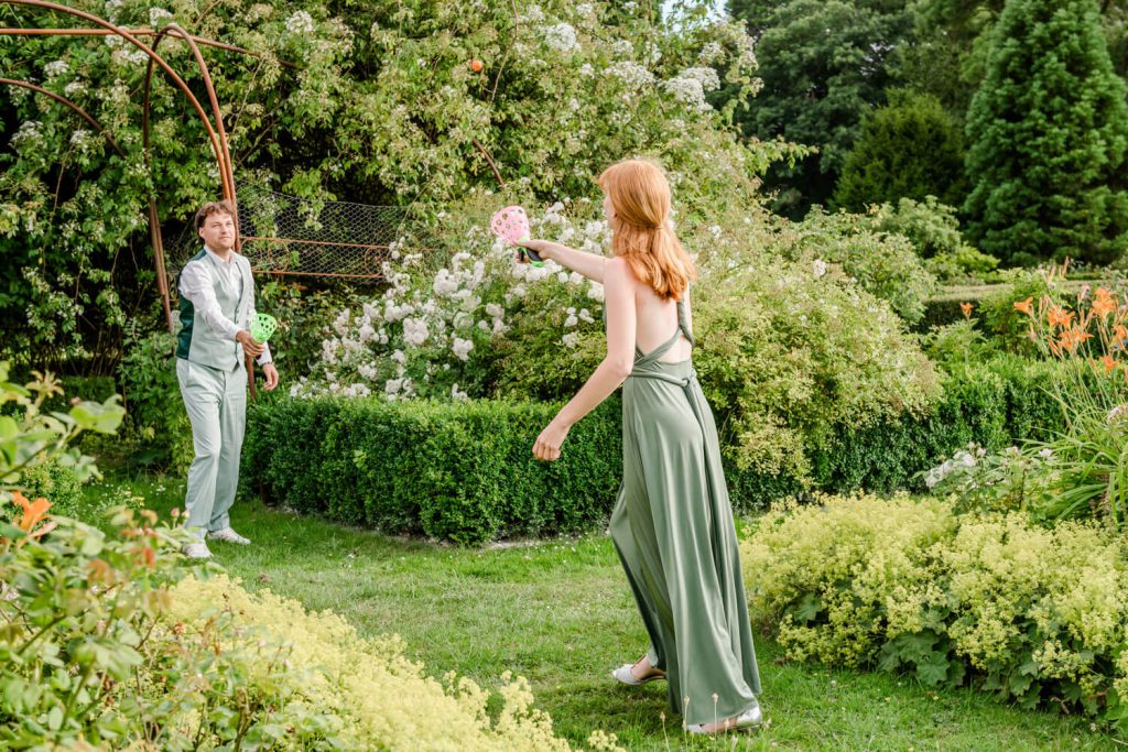 Zwei Personen spielen in einem Garten Verstecken.