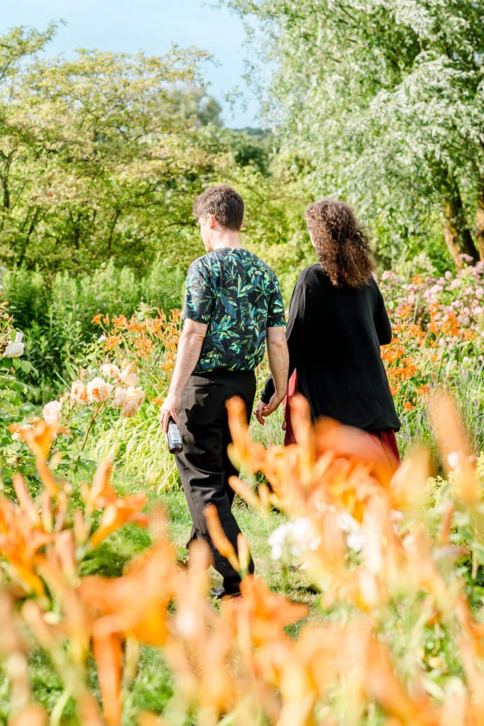 Paar spaziert durch blühenden Sommergarten zusammen