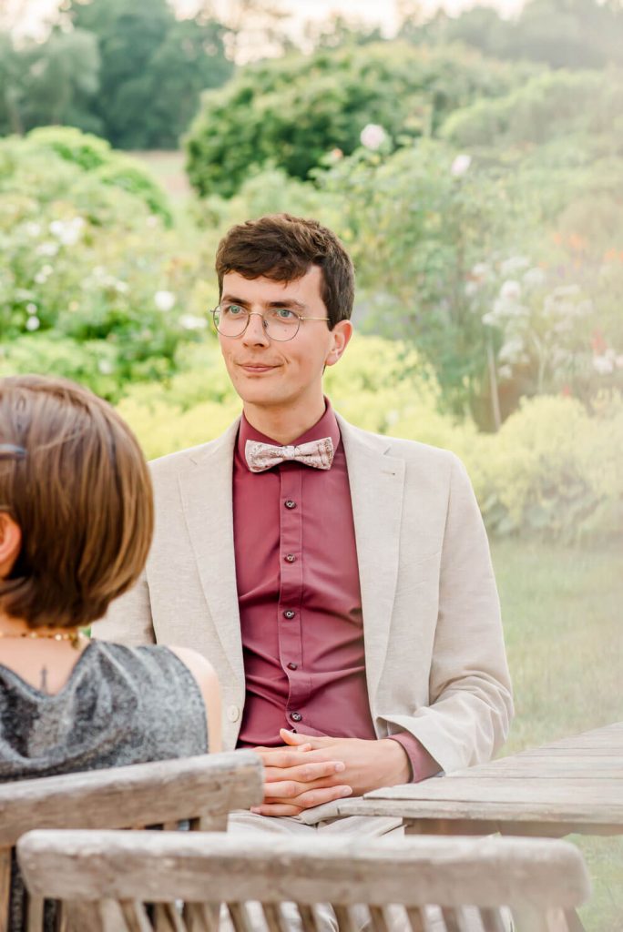 Junger Mann im Anzug im Garten sitzend