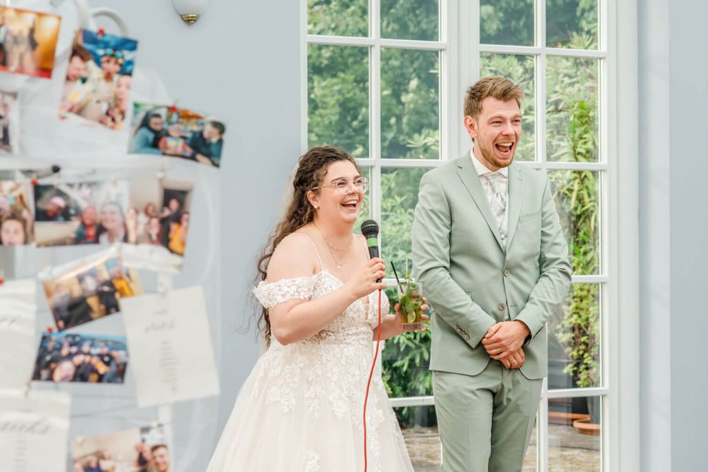 Brautpaar lacht während der Hochzeitsrede im Raum