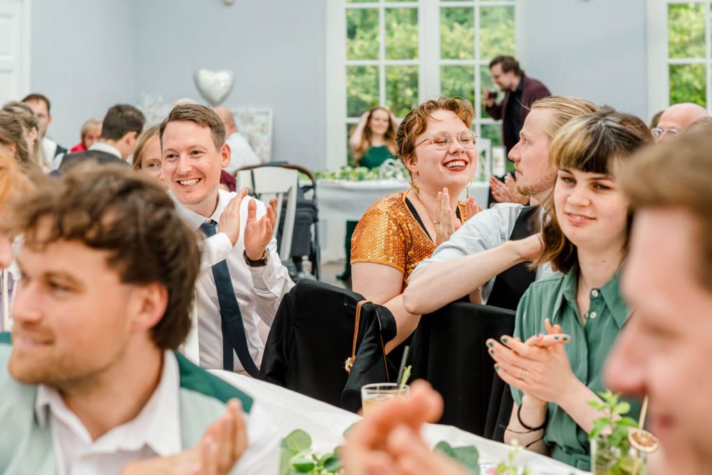 Menschen bei einer fröhlichen Veranstaltung applaudieren.