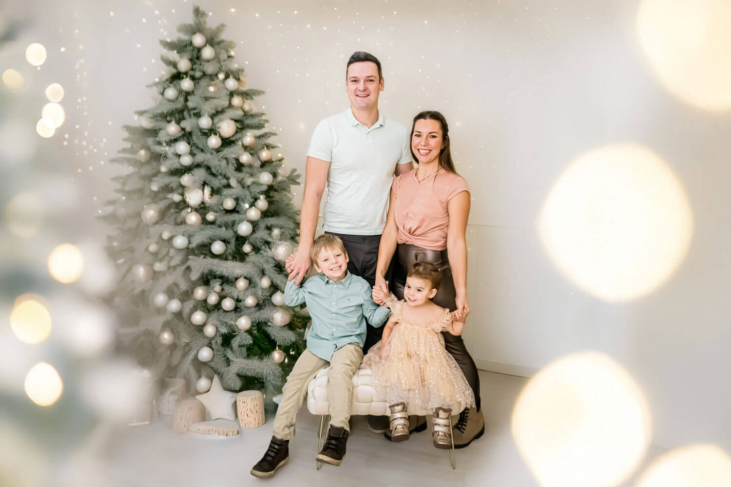 Familienfoto vor einem festlich geschmückten Weihnachtsbaum