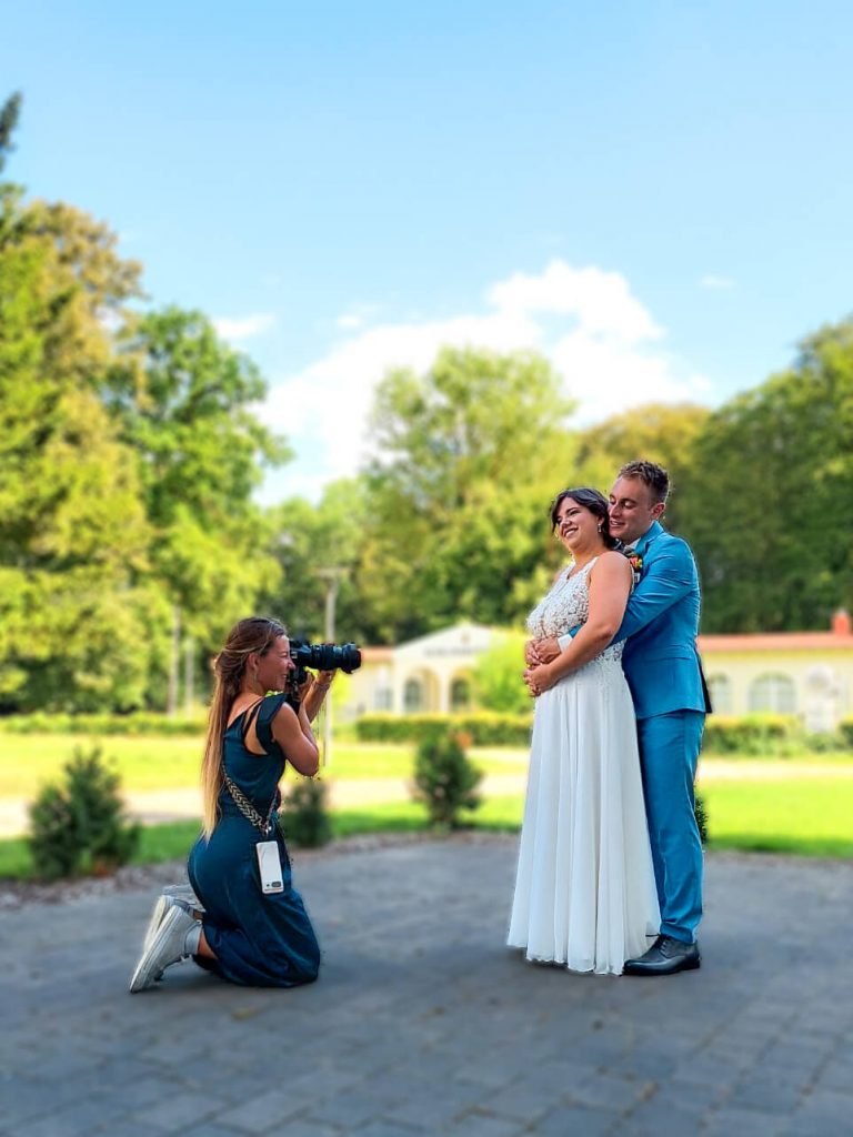 Fotograf macht Fotos von glücklichem Hochzeitspaar draußen