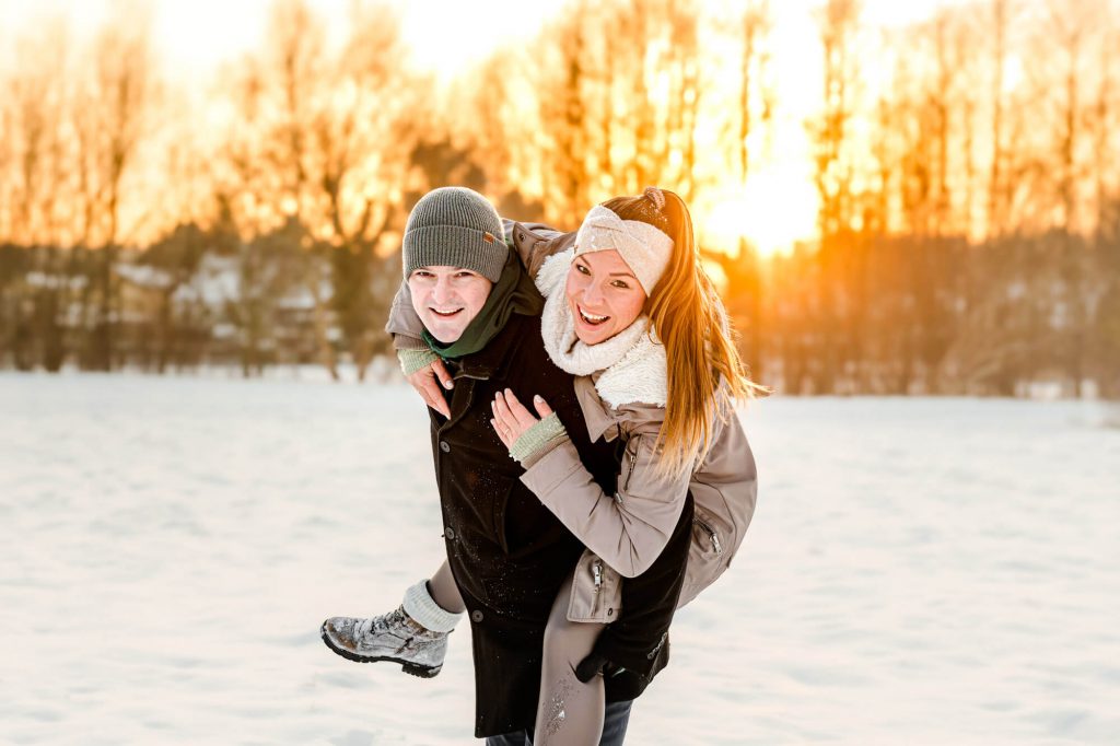 Junges Paar genießt sonnigen Wintertag im Schnee