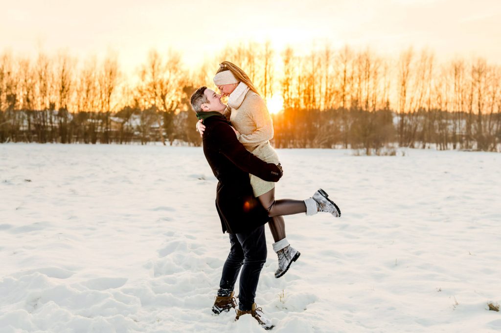 Paar genießt Wintersonne im verschneiten Feld