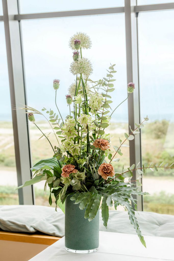 Großer Blumenstrauß in modernem Raum vor Fenster