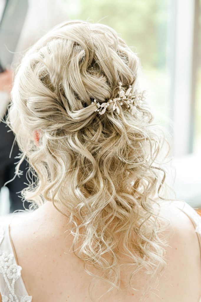 Blonde Brautfrisur mit eleganter Haarklammer und Locken