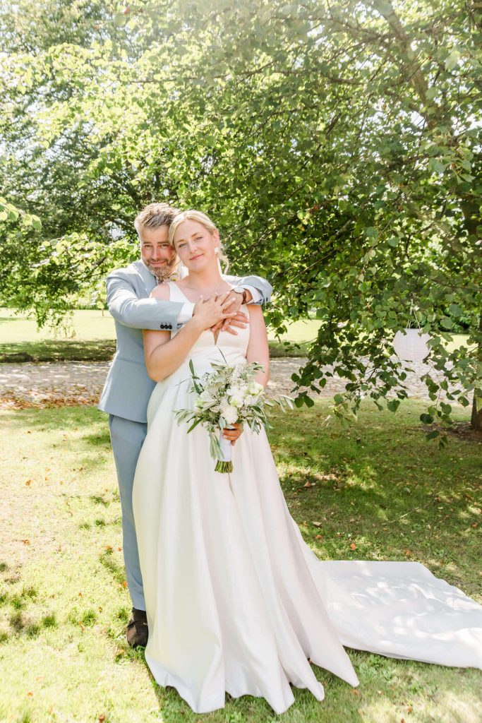 Frisch verheiratetes Paar im sonnigen Garten feiern