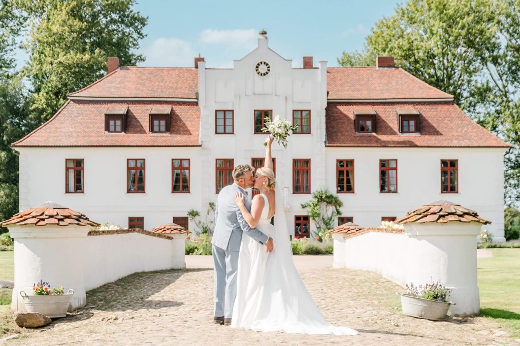 Brautpaar vor einem romantischen weißen Schloss