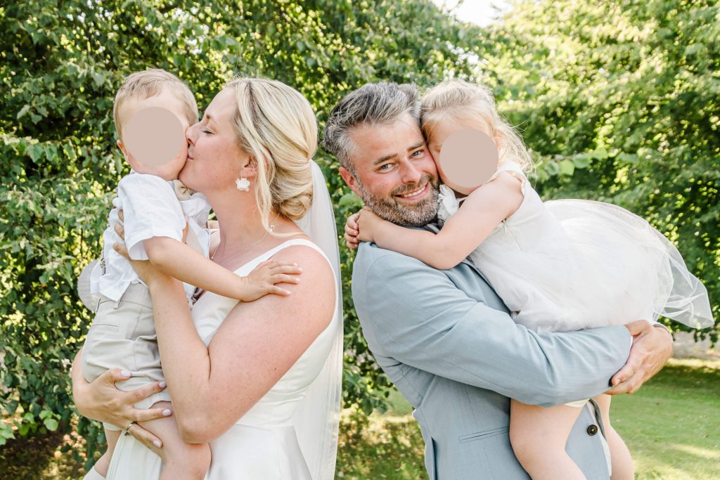 Paar mit Kindern bei einer Hochzeit im Freien