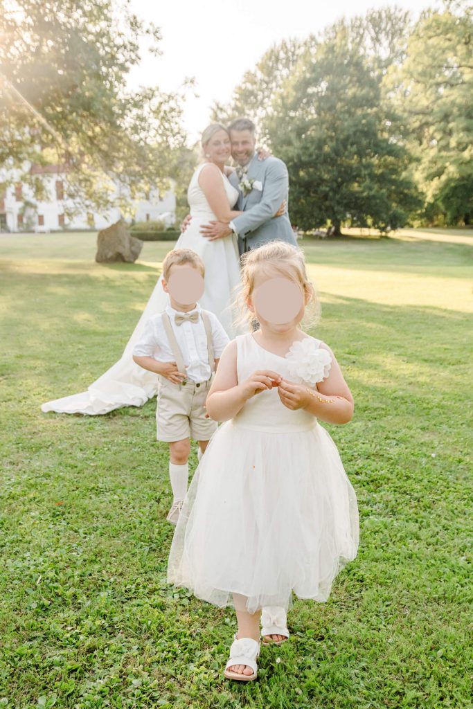 Brautpaar mit Kindern bei einer Hochzeit draußen