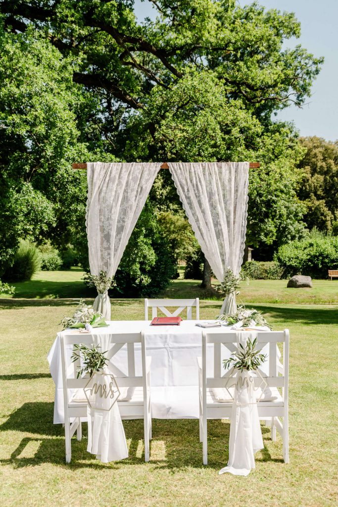 Hochzeitsdekoration im Freien mit weißen Stühlen