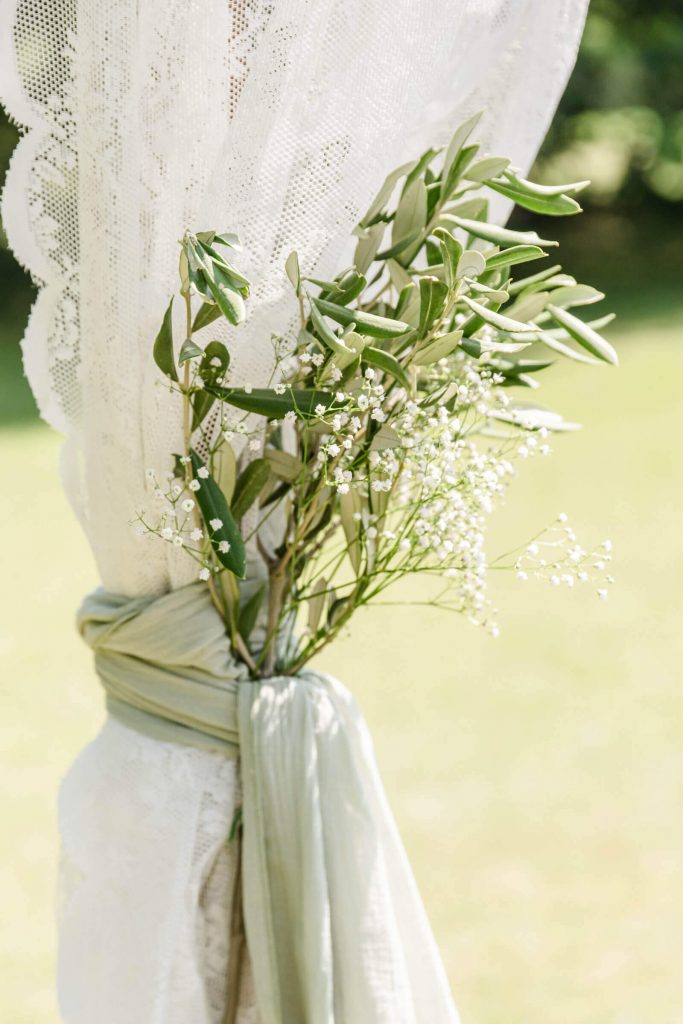 Pflanzenarrangement mit Schleierkraut auf Spitzenvorhang draußen