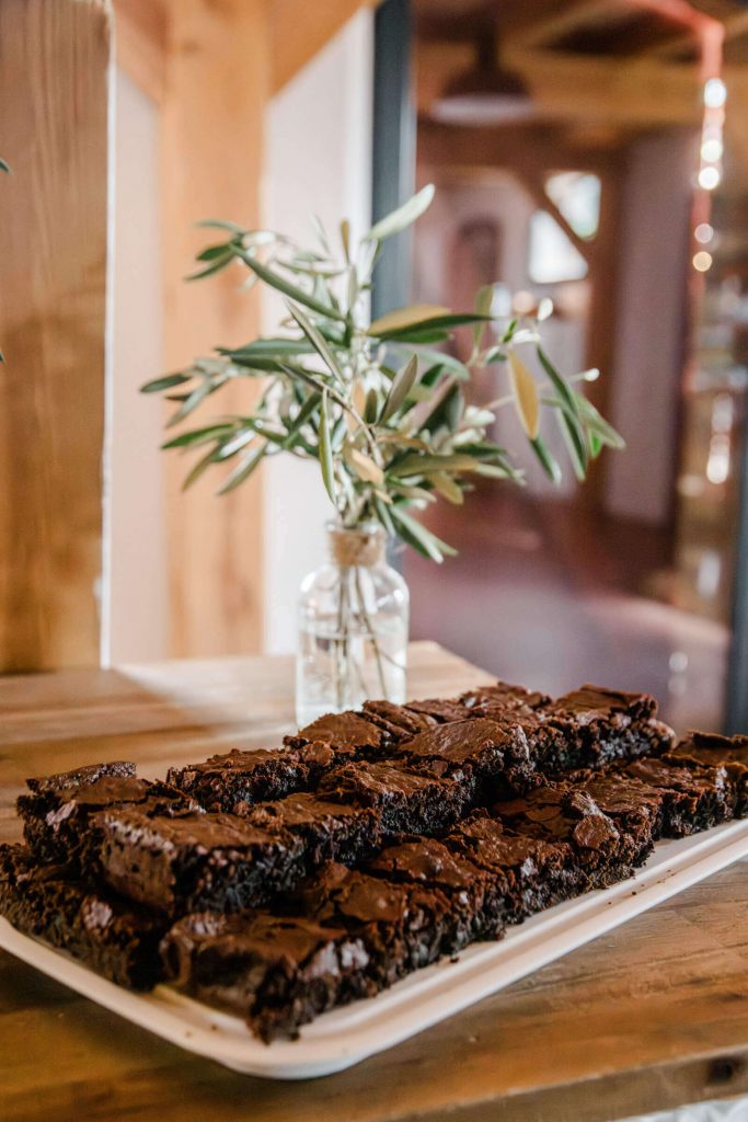 Hausgemachte Brownies auf Teller vor Olivenzweig