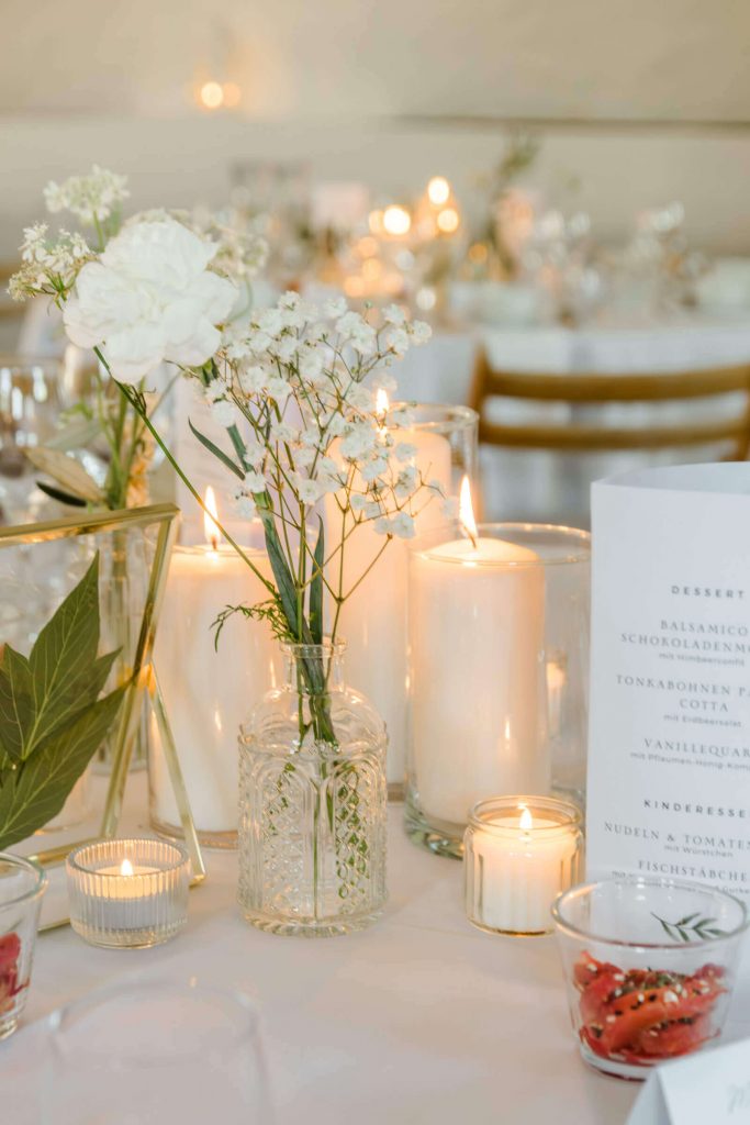 Elegante Tischdekoration mit Kerzen und Blumenvasen