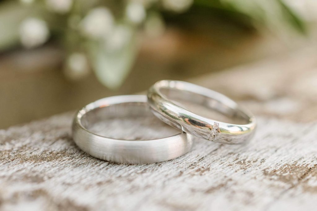 Zwei Eheringe auf rustikalem Holztisch liegend