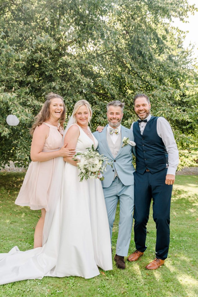 Hochzeitsgesellschaft posiert glücklich im Gartenbereich