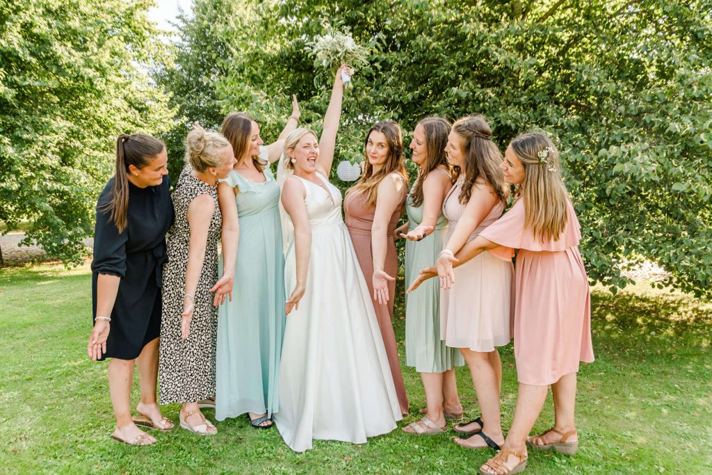 Braut mit Brautjungfern im Garten feiern