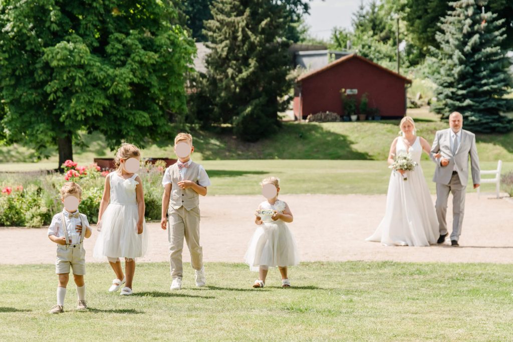Hochzeitsgesellschaft spaziert auf einer sonnigen Wiese