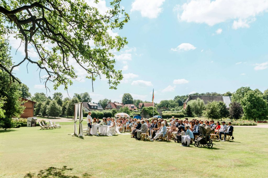 Gartenhochzeit mit Gästen an einem sonnigen Tag