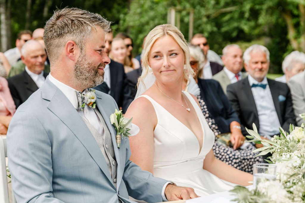 Brautpaar lächelt bei der Hochzeitszeremonie im Freien