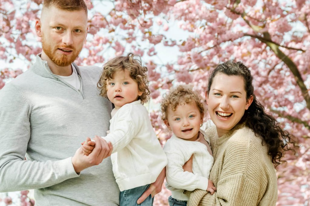 Glückliche Familie mit blühenden Kirschbäumen draußen