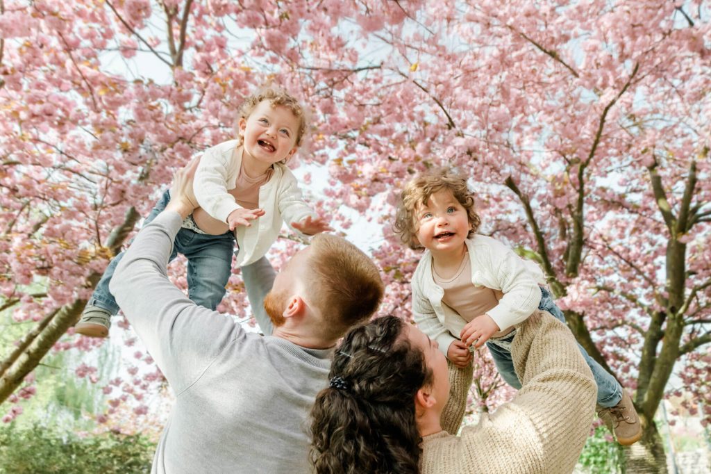 Familie mit Kindern unter blühendem Kirschbaum