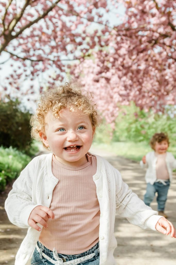Lachende Kinder unter blühenden Kirschbäumen im Frühling